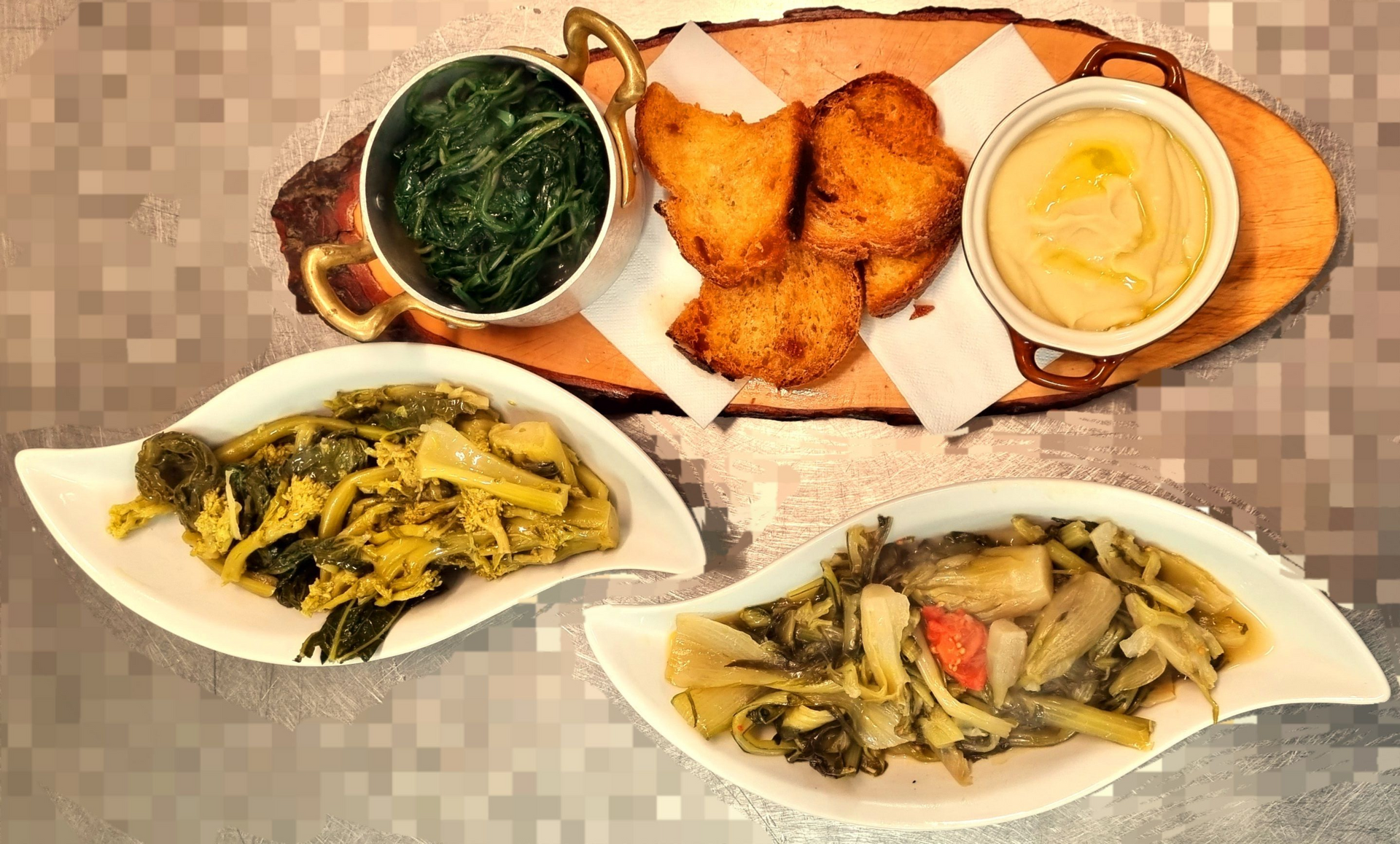 Piatti vari: spinaci, impanati, hummus e contorni di verdure su un tagliere di legno e piatti bianchi.
