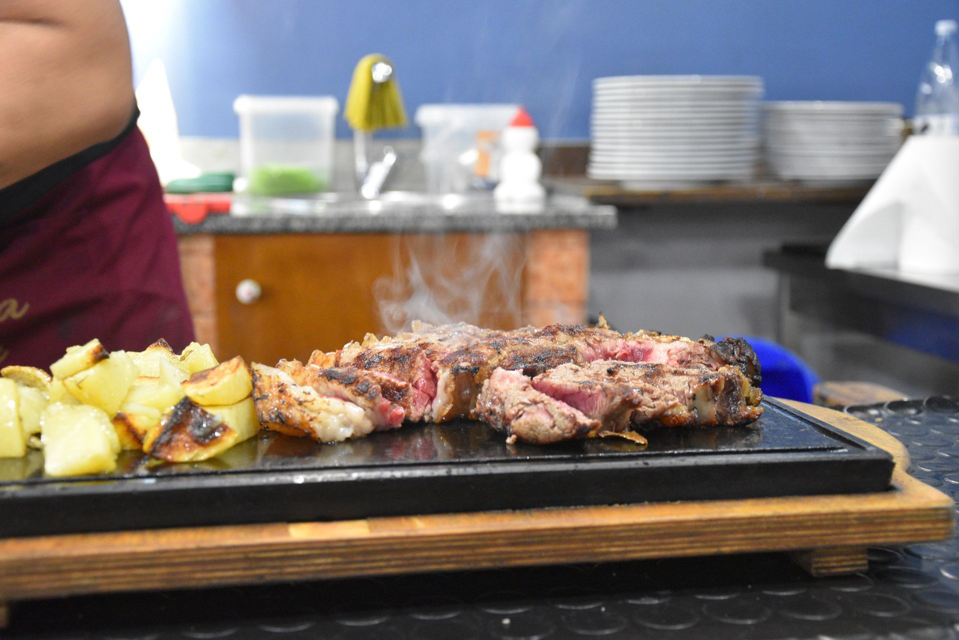 Bistecca tagliata a fette e scottata alla griglia, al sangue, con interno rosa e crosta scura, cosparsa di sale.