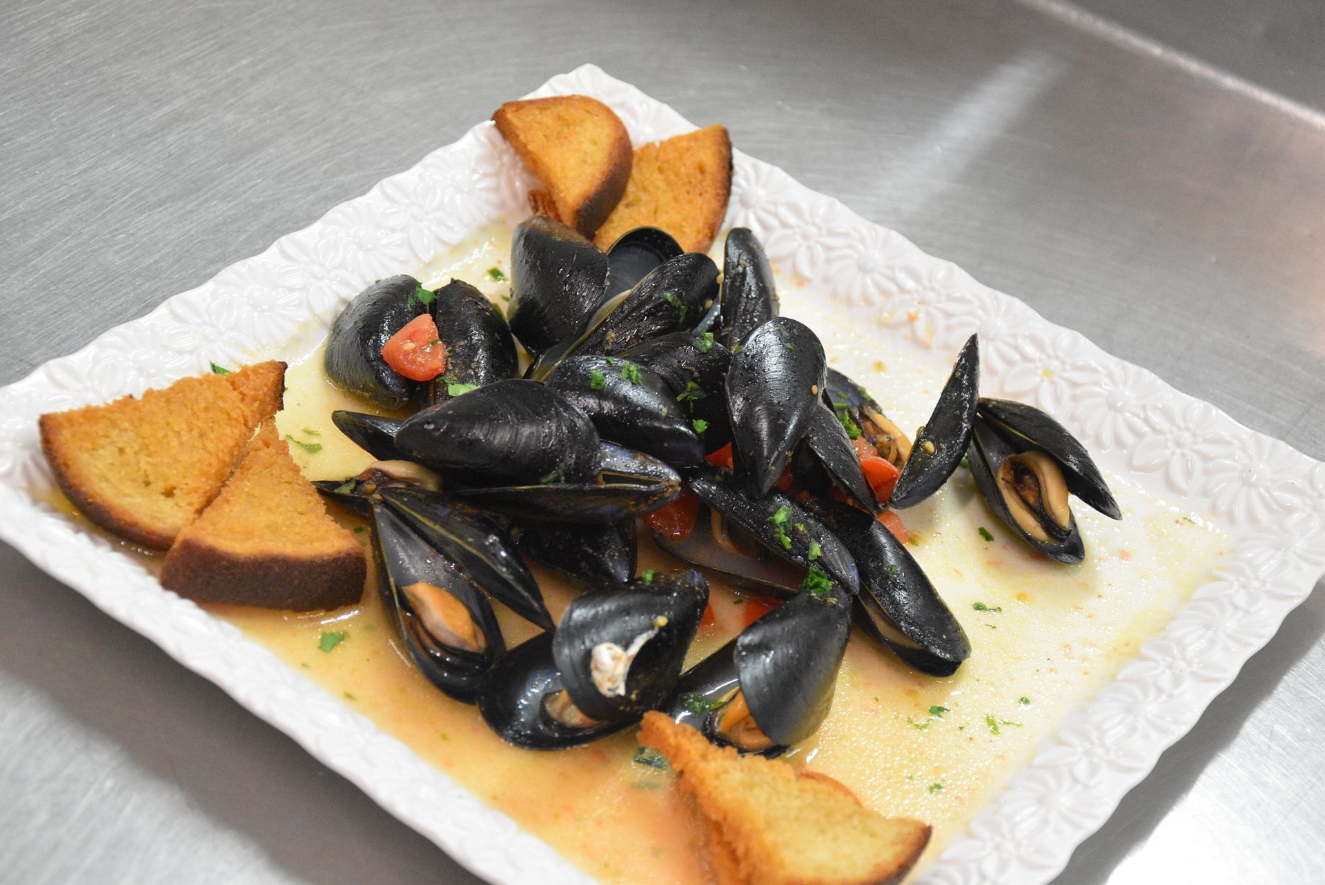 Piatto di pasta con cozze, gamberi e frutti di mare.