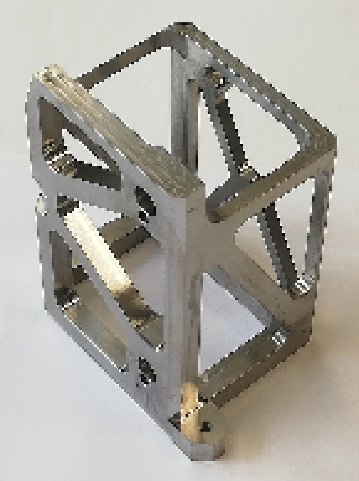 A metal cube is sitting on a white surface.