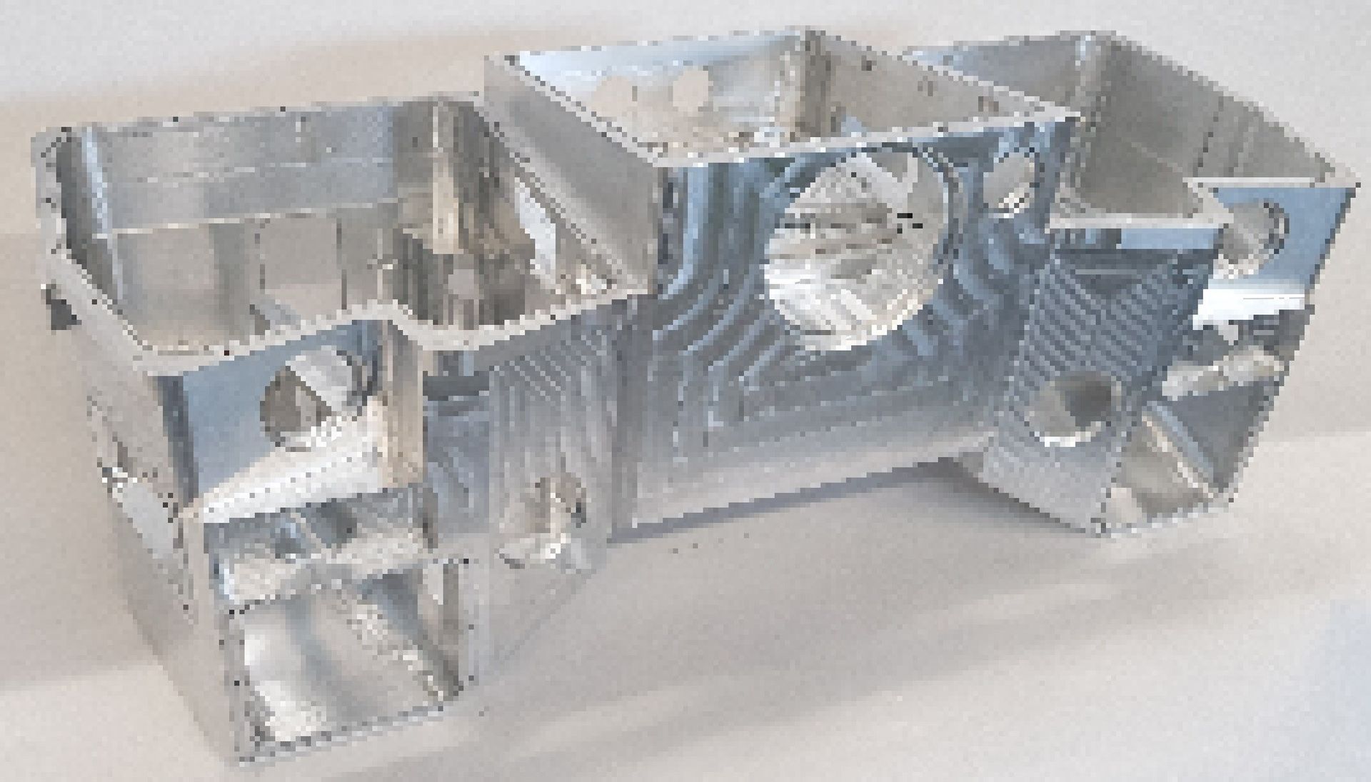 A silver metal object is sitting on a white surface.