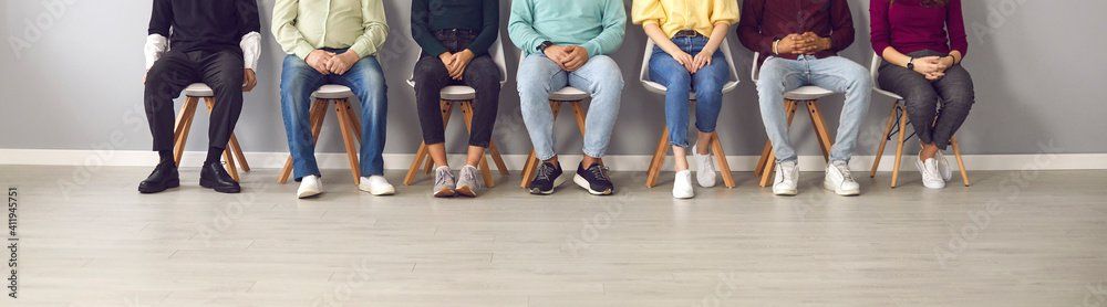 A group of people are sitting in chairs in a row.