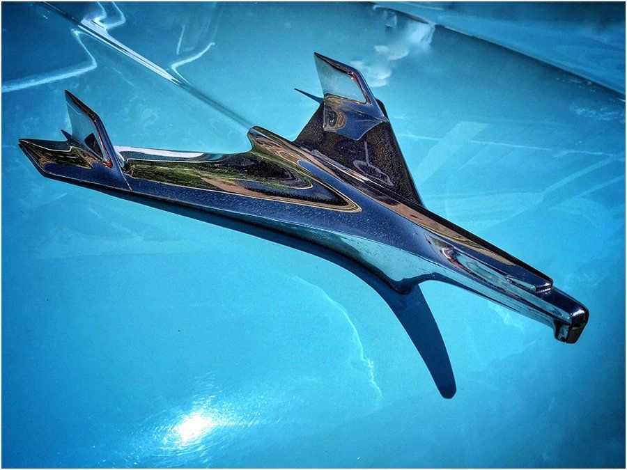 A chrome airplane emblem is sitting on a blue surface