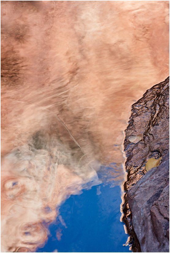 A reflection of a mountain in a body of water.