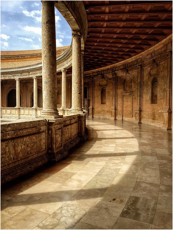 A long hallway with columns and a wooden ceiling