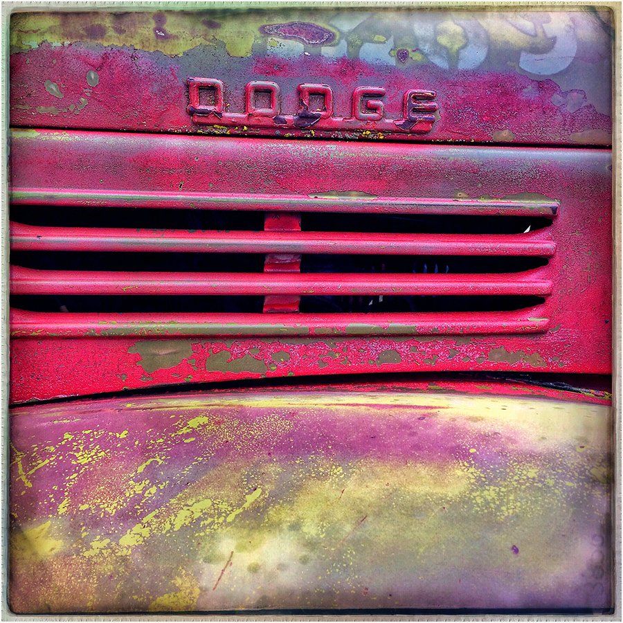 A close up of the front of a red dodge truck