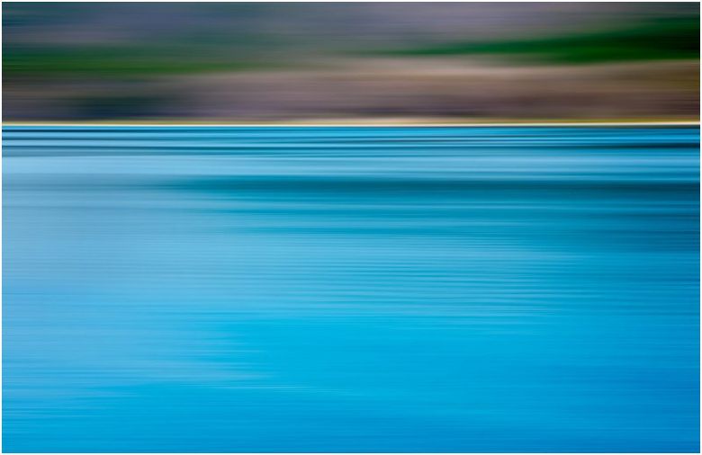 A blurry picture of a body of water with trees in the background.
