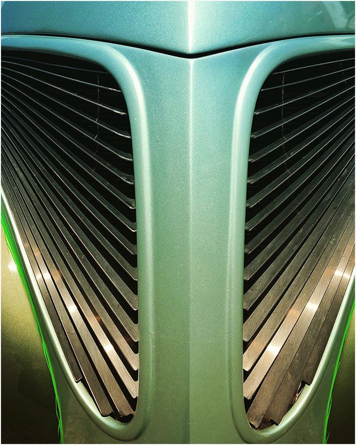A close up of the front of a green car