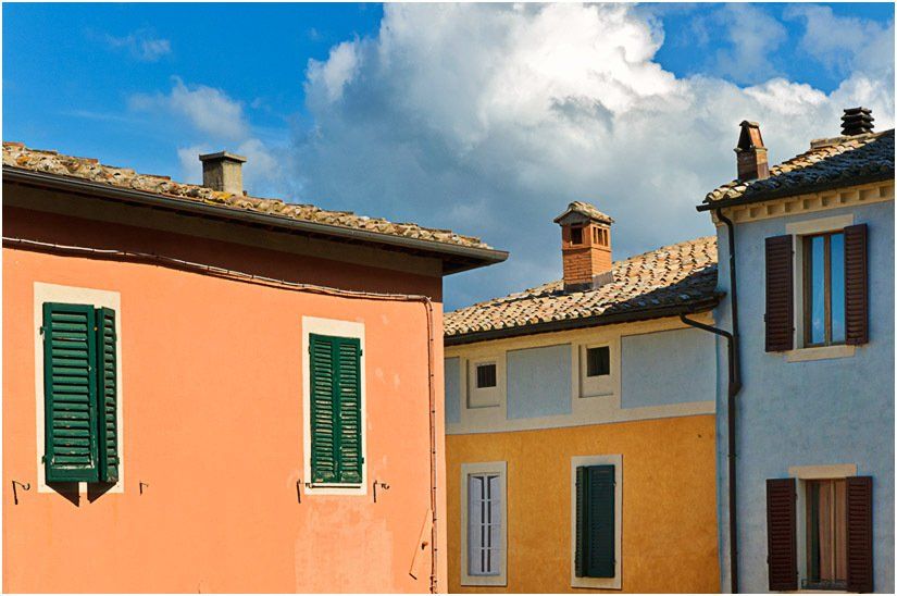 A row of buildings with green shutters on the windows