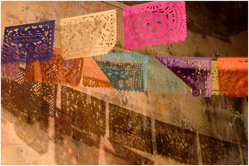 A bunch of colorful paper flags hanging on a wall