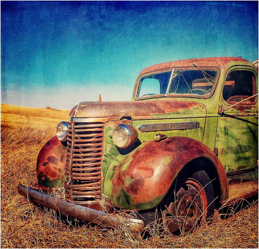 An old rusty green truck with the word sierra on the front
