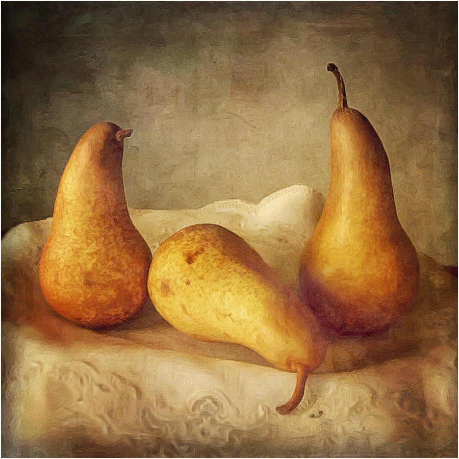 Three pears are sitting on a white cloth on a table.