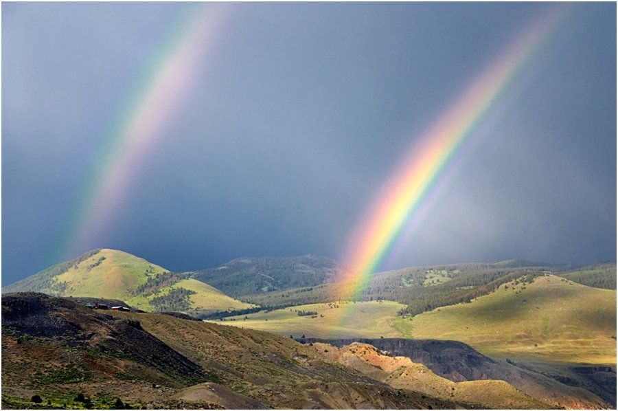 There is a double rainbow over the mountains.