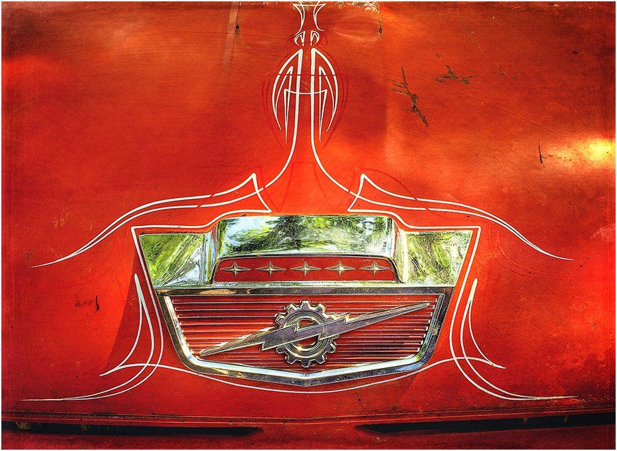 A close up of a red car with a logo on it