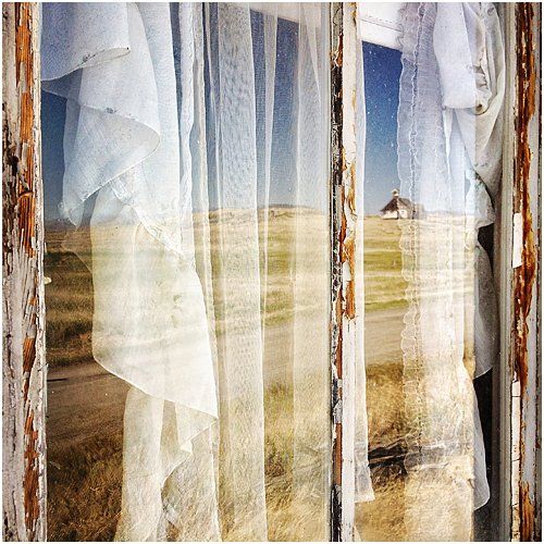 Curtains in a window with refelction of the country side.