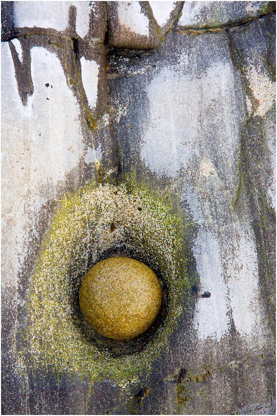 A close up of a rock in a hole on a wall.