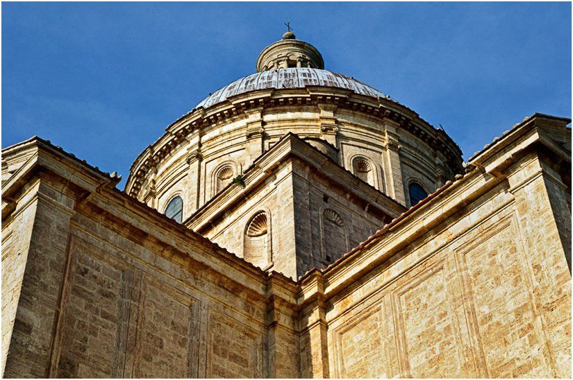Looking up at the dome of a building with a blue sky in the background