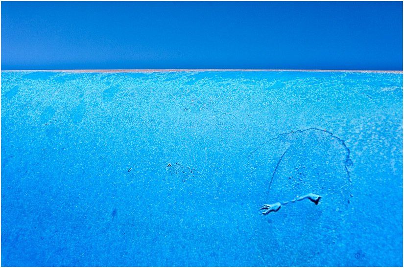 An aerial view of a swimming pool with a blue sky in the background.