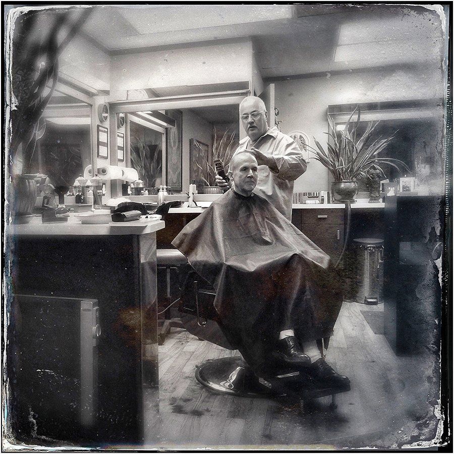 A man is getting his hair cut at a barber shop