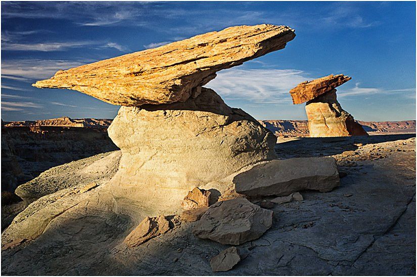 A rock formation in the desert with a blue sky in the background