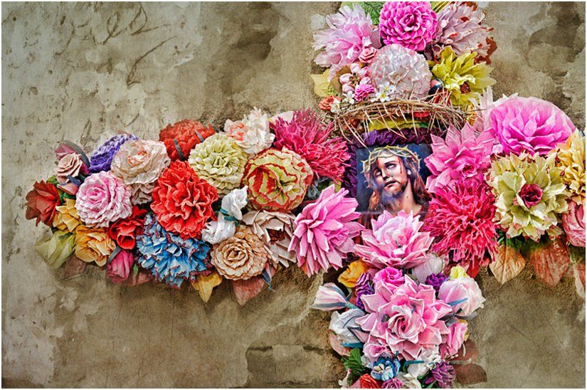 A cross made of flowers with a picture of jesus on it