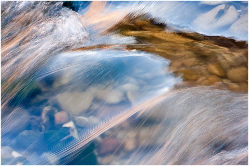 A blurry picture of a river with mountains in the background