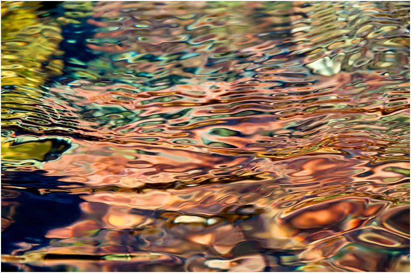 A close up of a river with a lot of water and rocks in it.