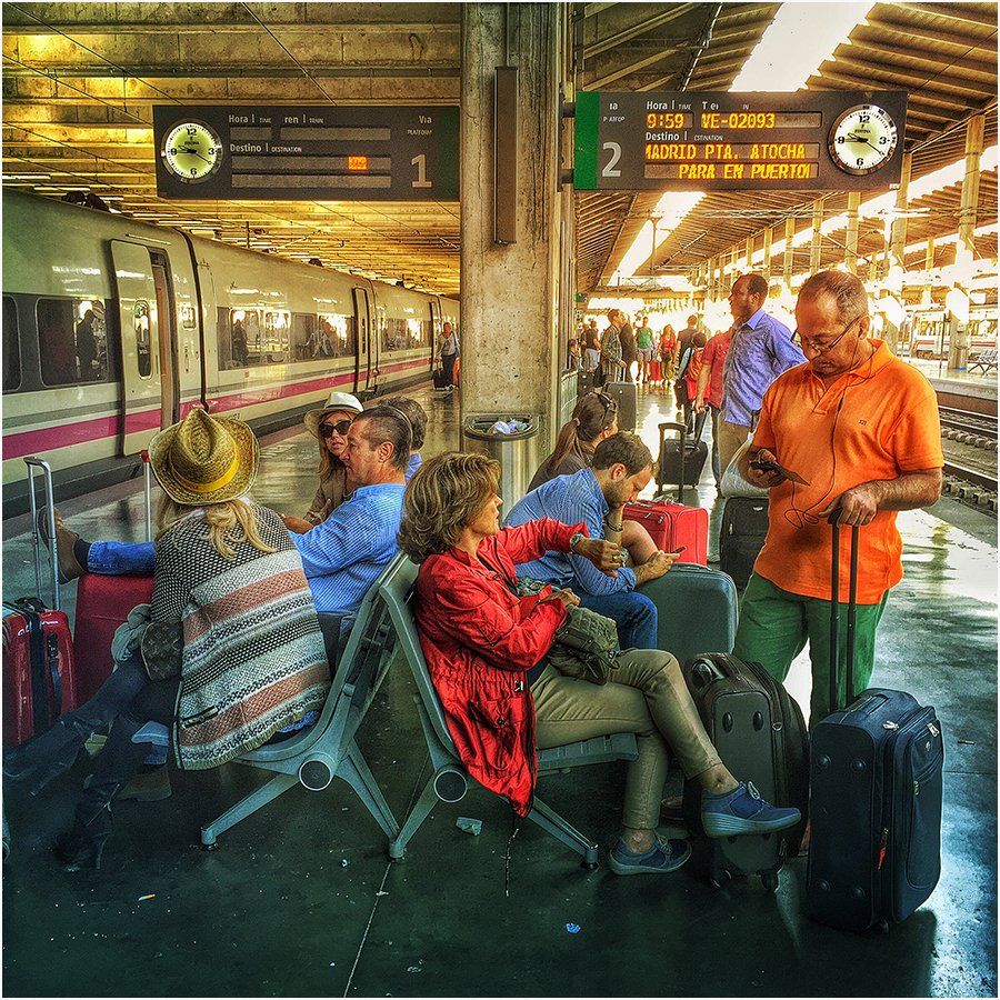 A group of people are waiting for a train at a train station