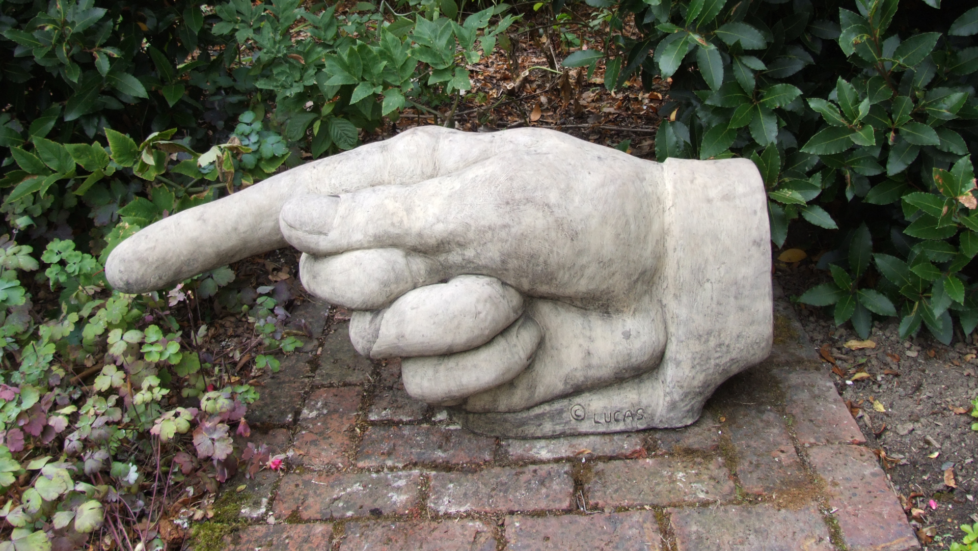 pointing hand stone garden statue