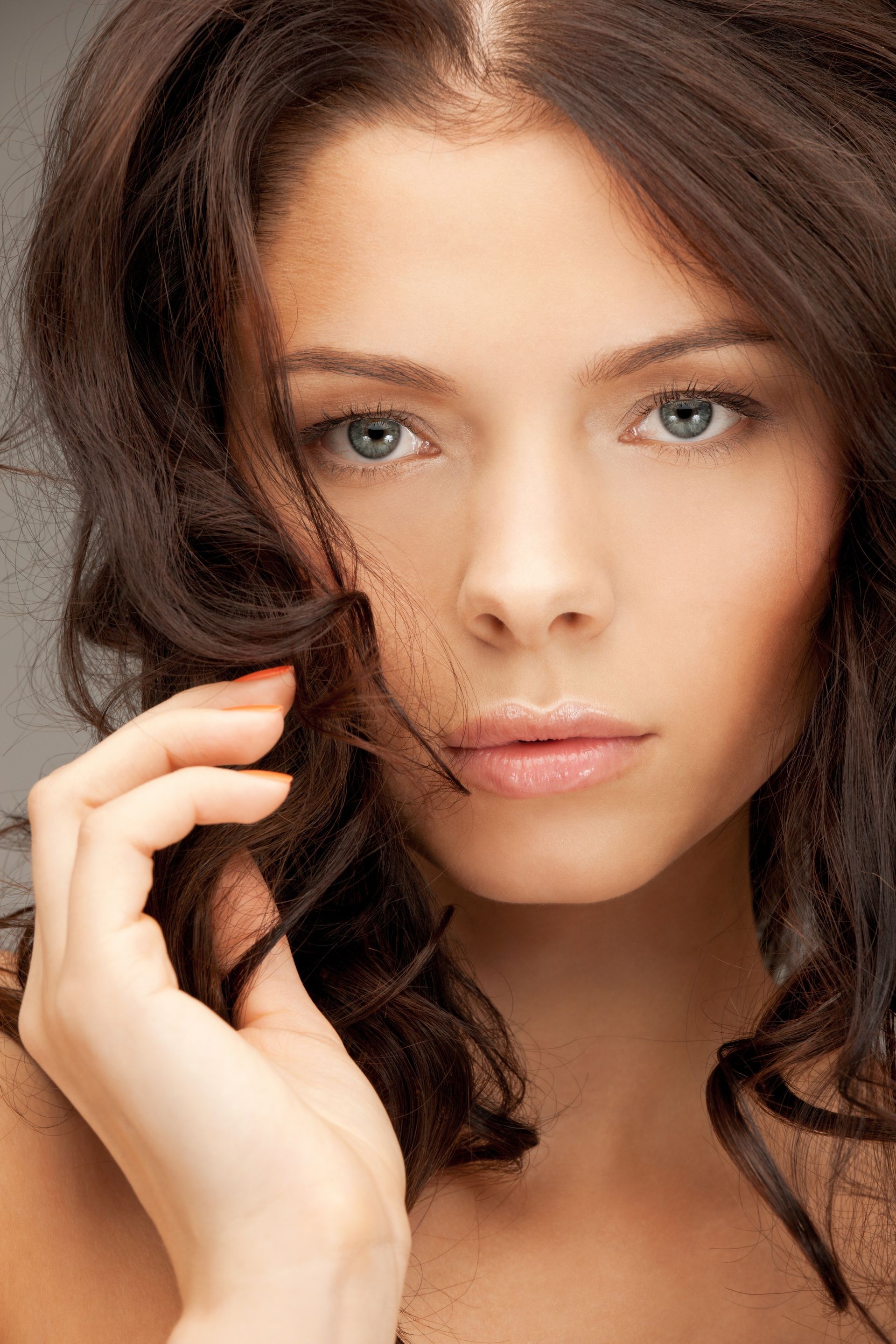 A woman is holding her hair in front of her face.