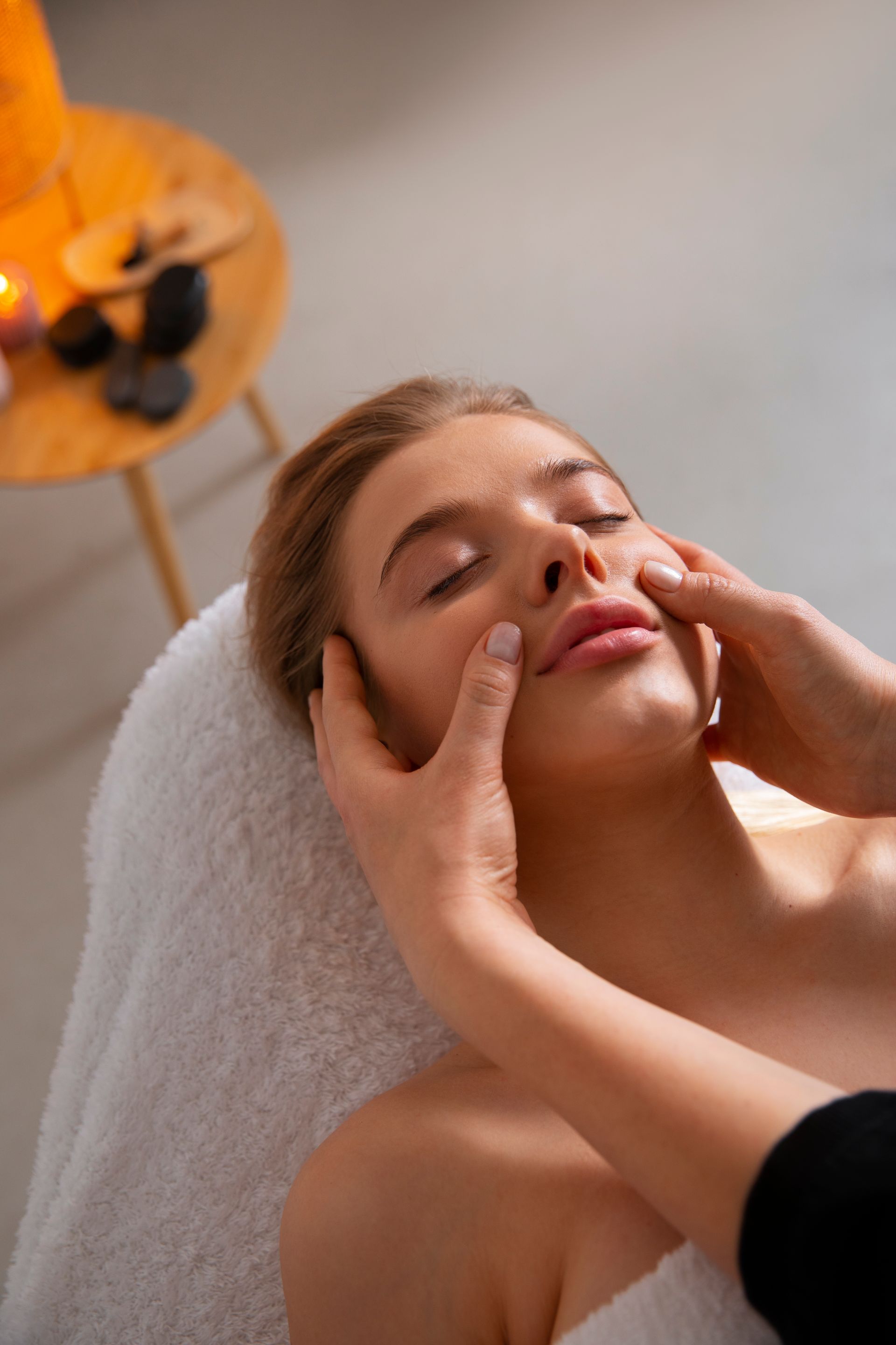 A woman is getting a facial massage at a spa.