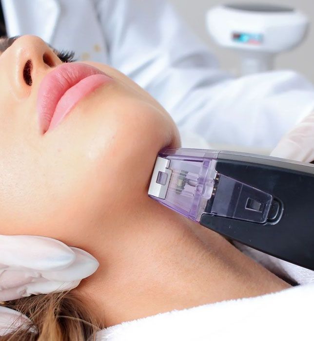 A woman is getting a laser treatment on her neck.