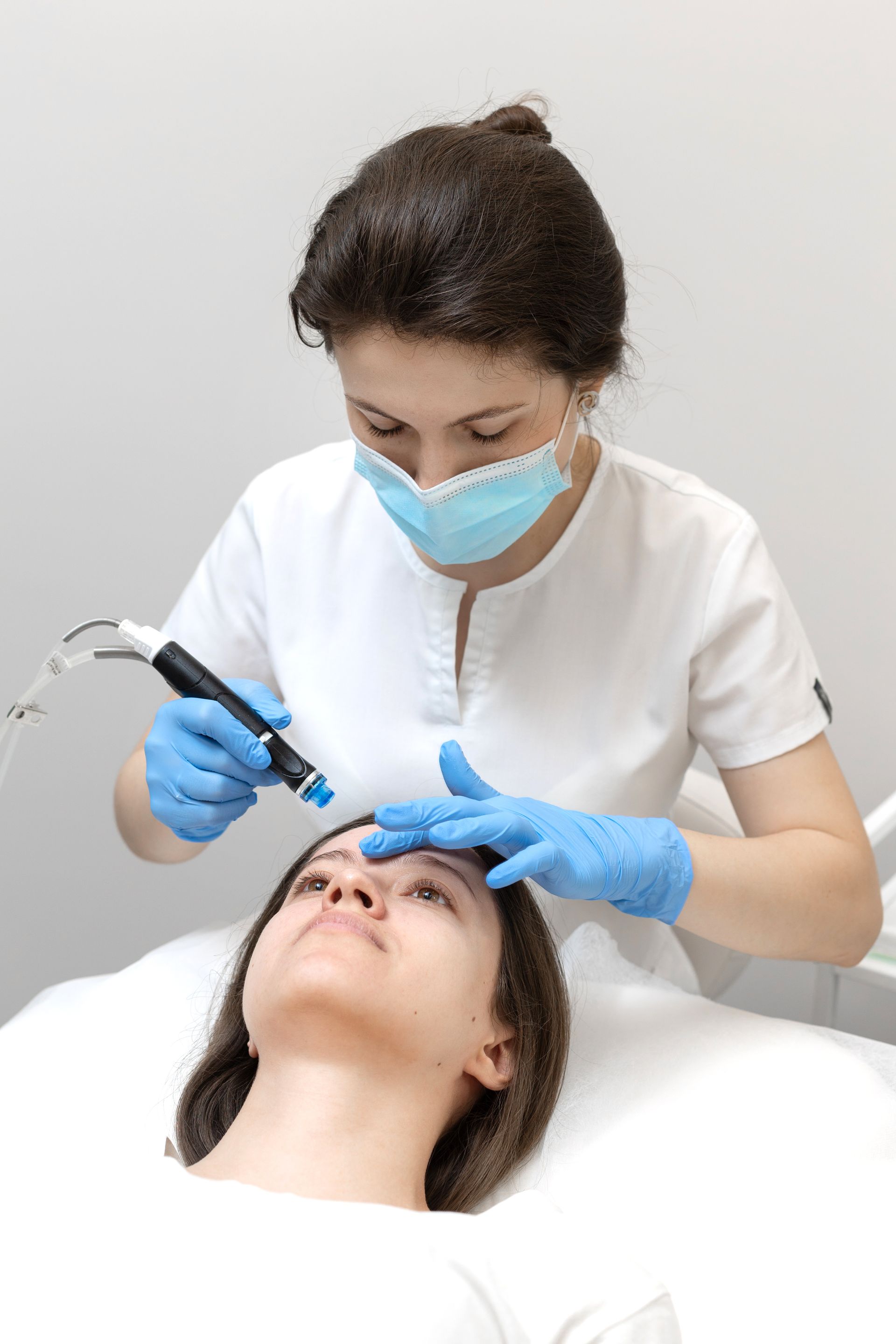 A woman is getting a facial treatment at a beauty salon.