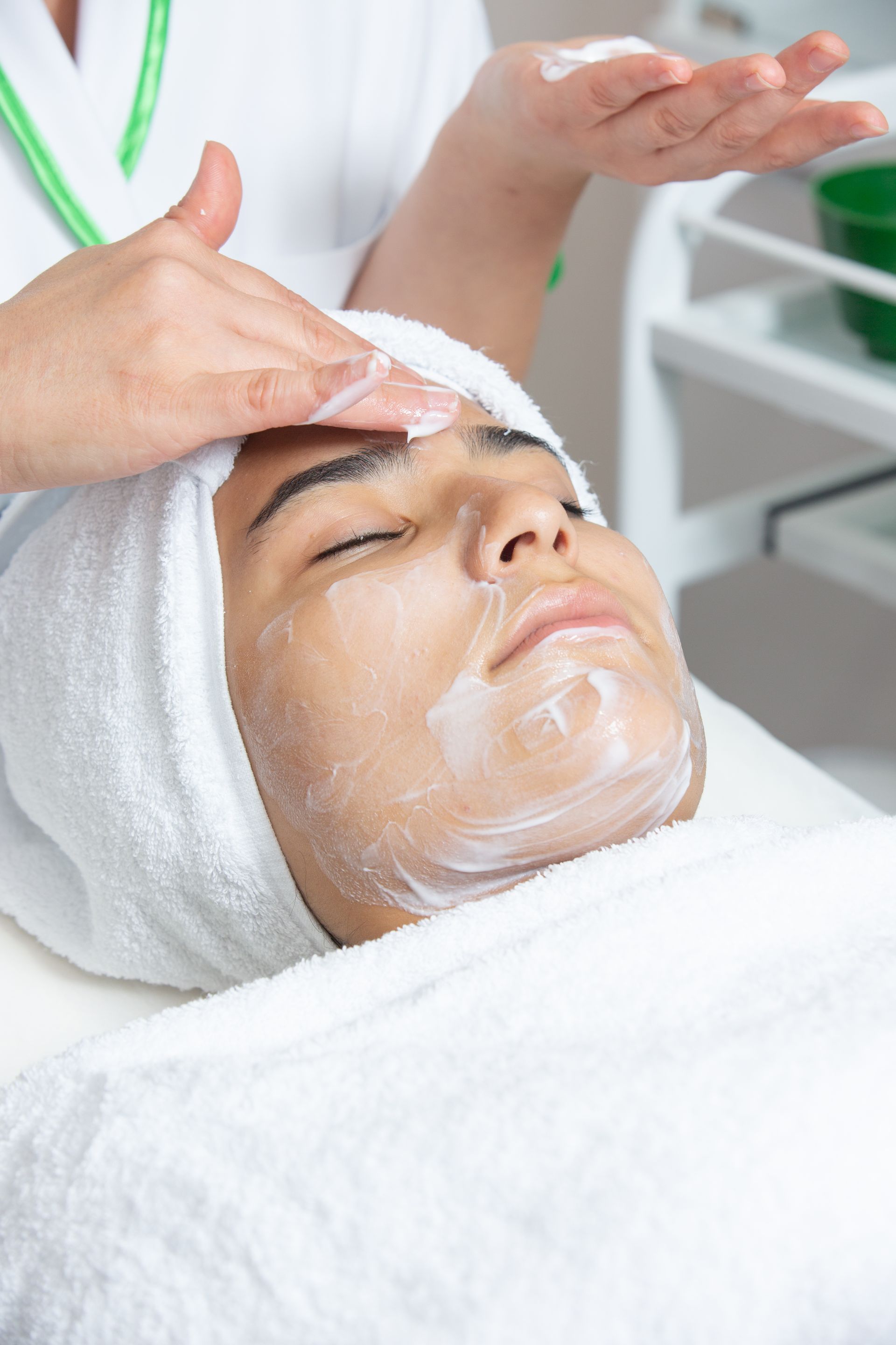 A man is getting a facial treatment at a spa.