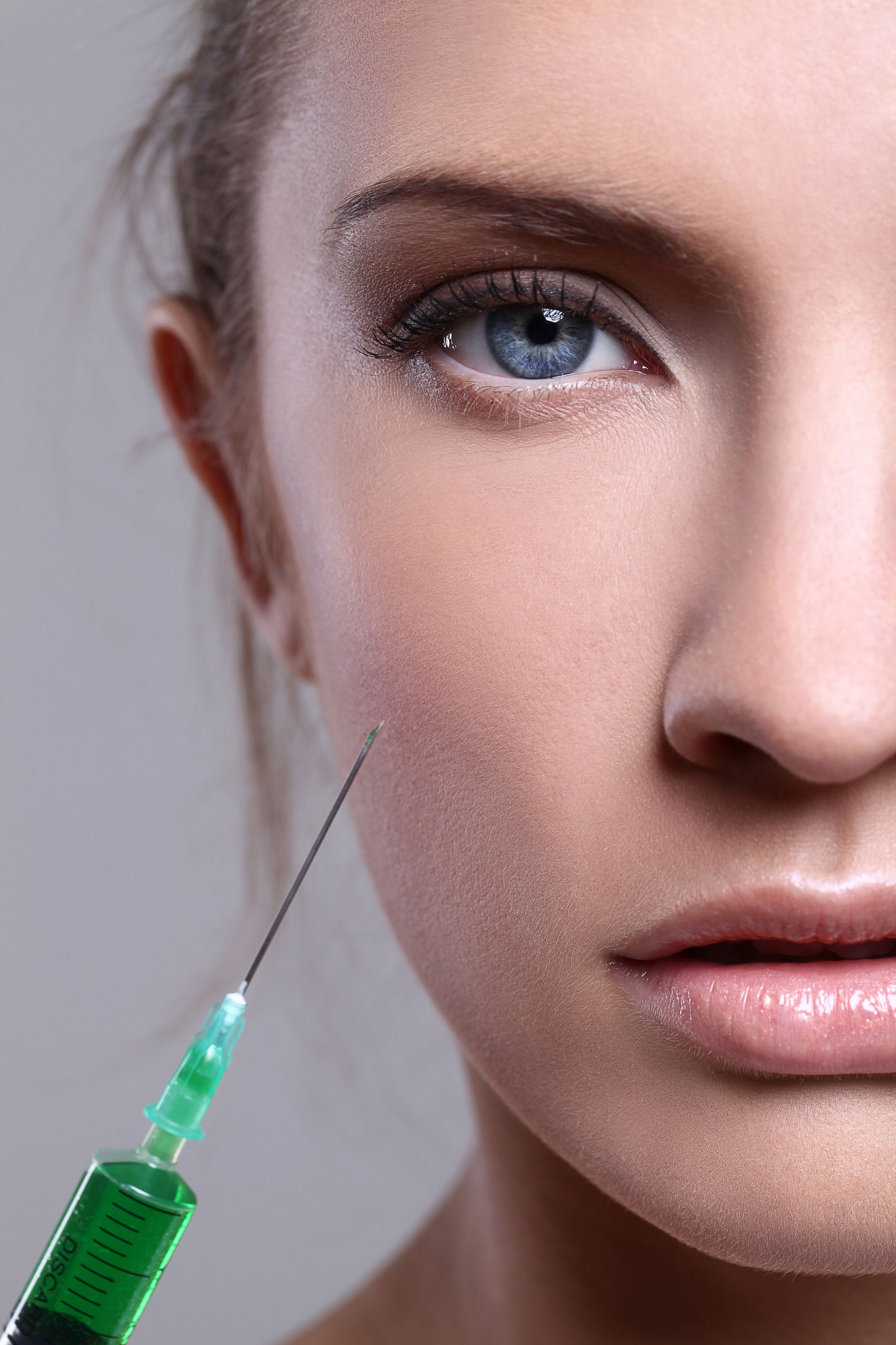 A woman is getting a botox injection in her face.