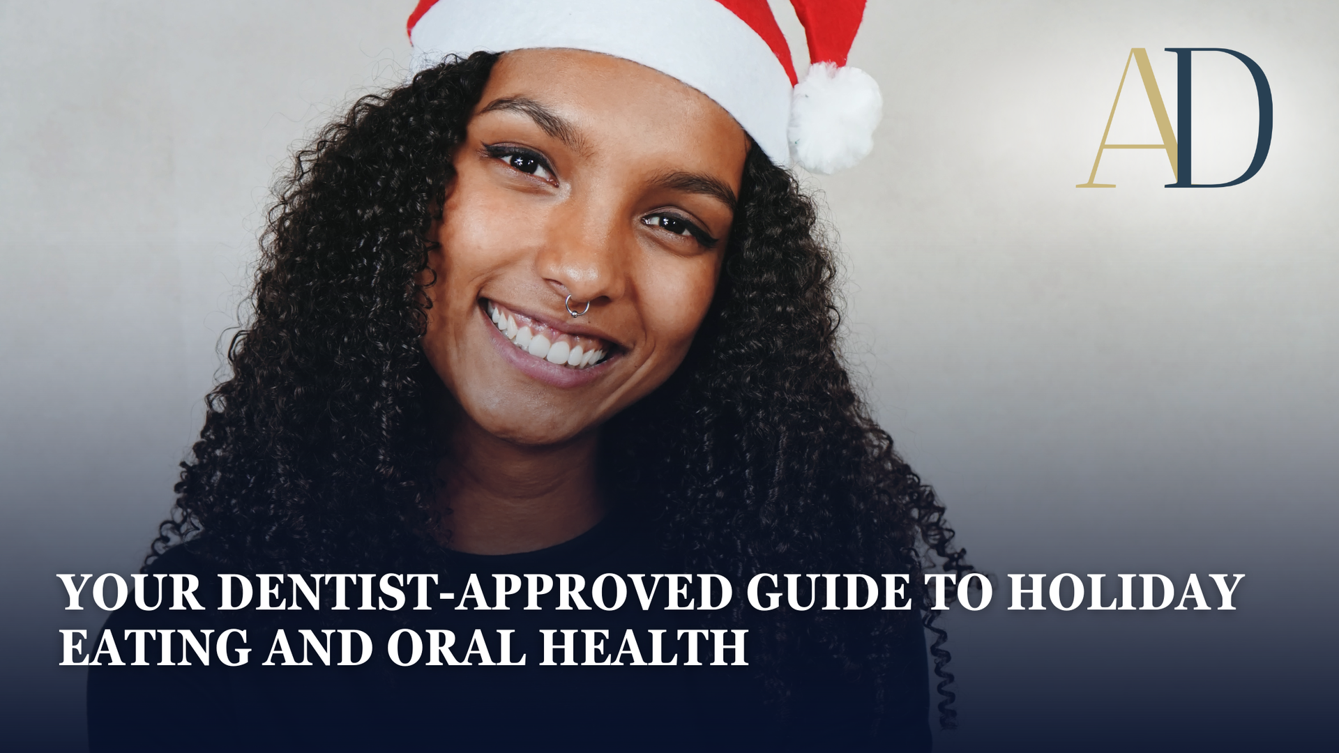 Smiling woman in Santa hat with text: “Your dentist-approved guide to holiday eating and oral health”