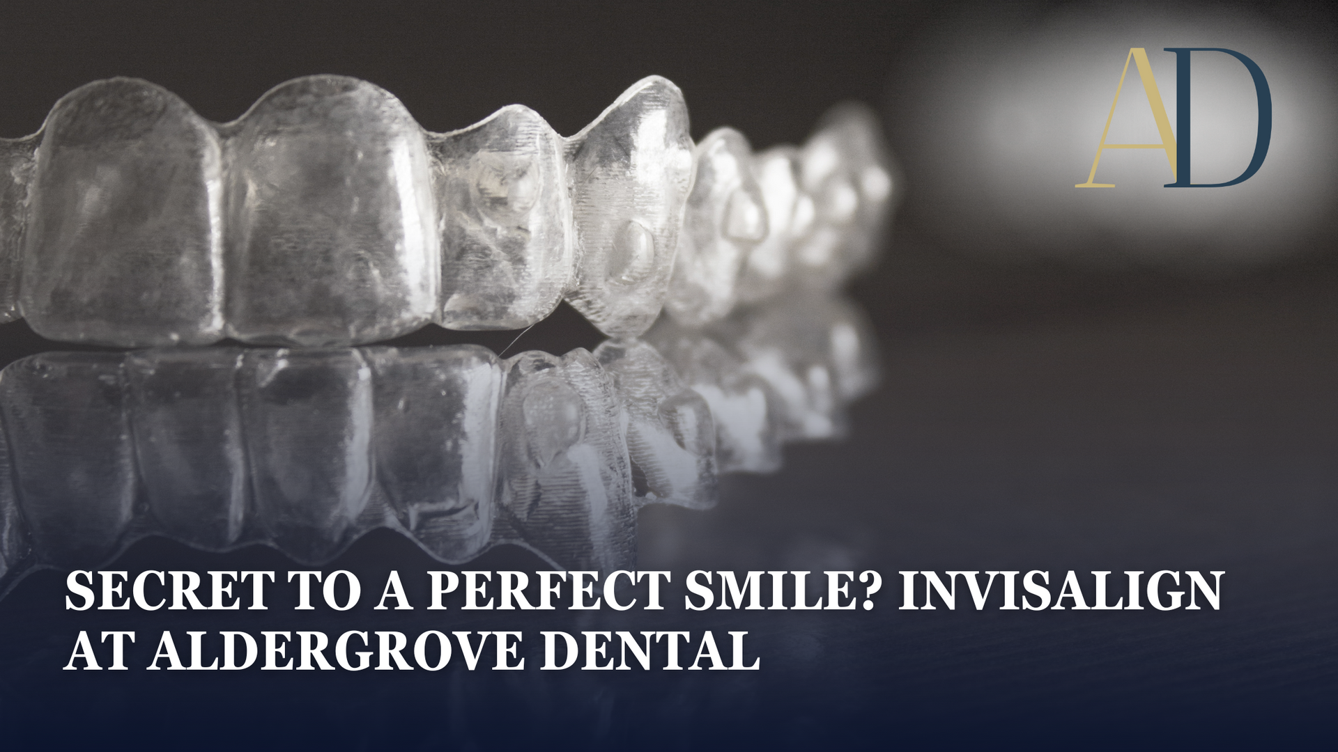 Clear Invisalign aligners on a reflective surface with “Secret to a perfect smile? Invisalign at Aldergrove Dental.”