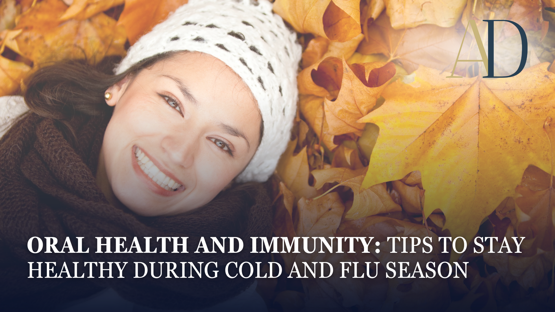 Smiling person in a white knit hat among autumn leaves with text: Oral health and immunity tips for cold and flu season