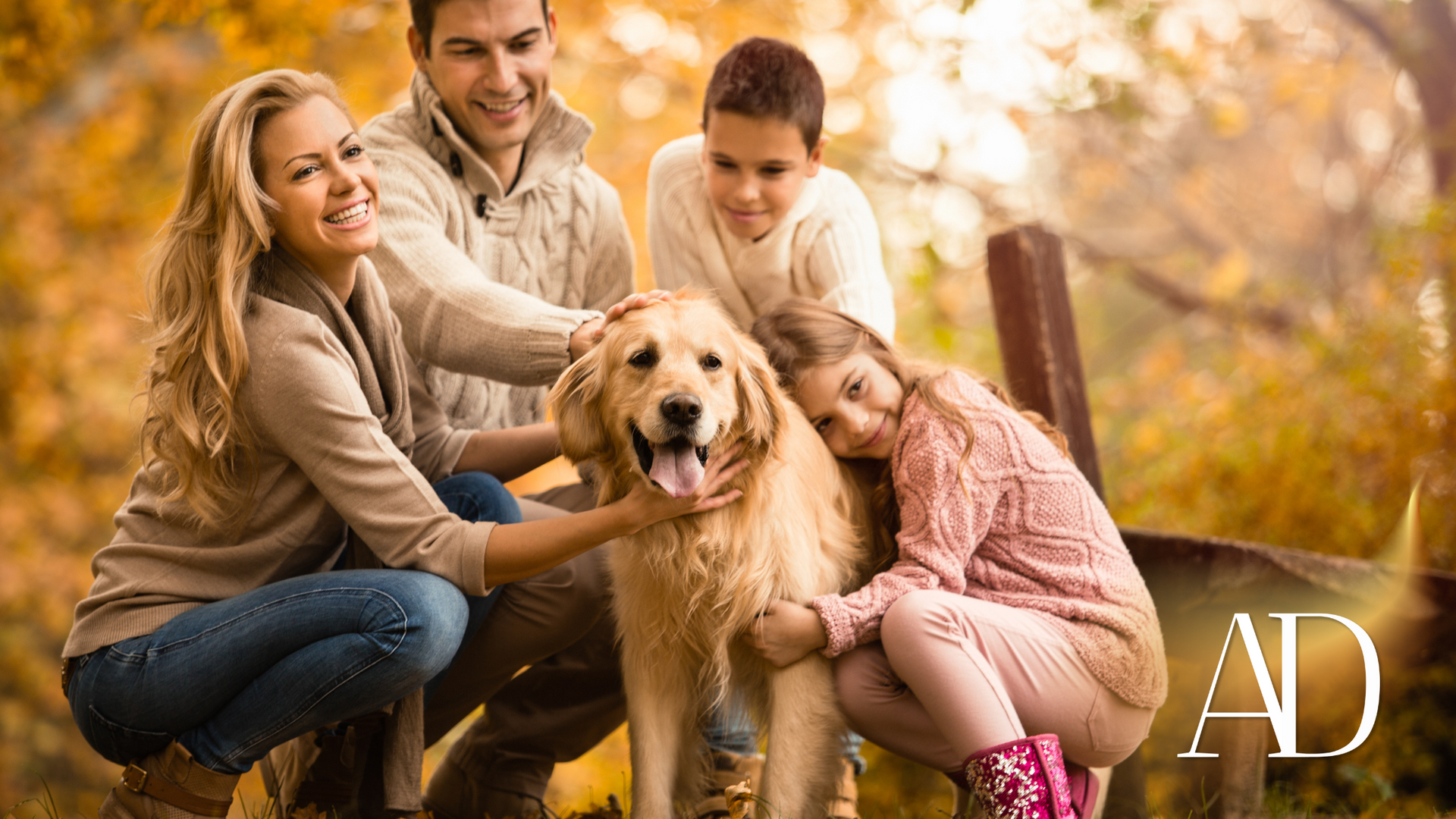 Family with a golden retriever in an autumn park, smiling and petting the dog