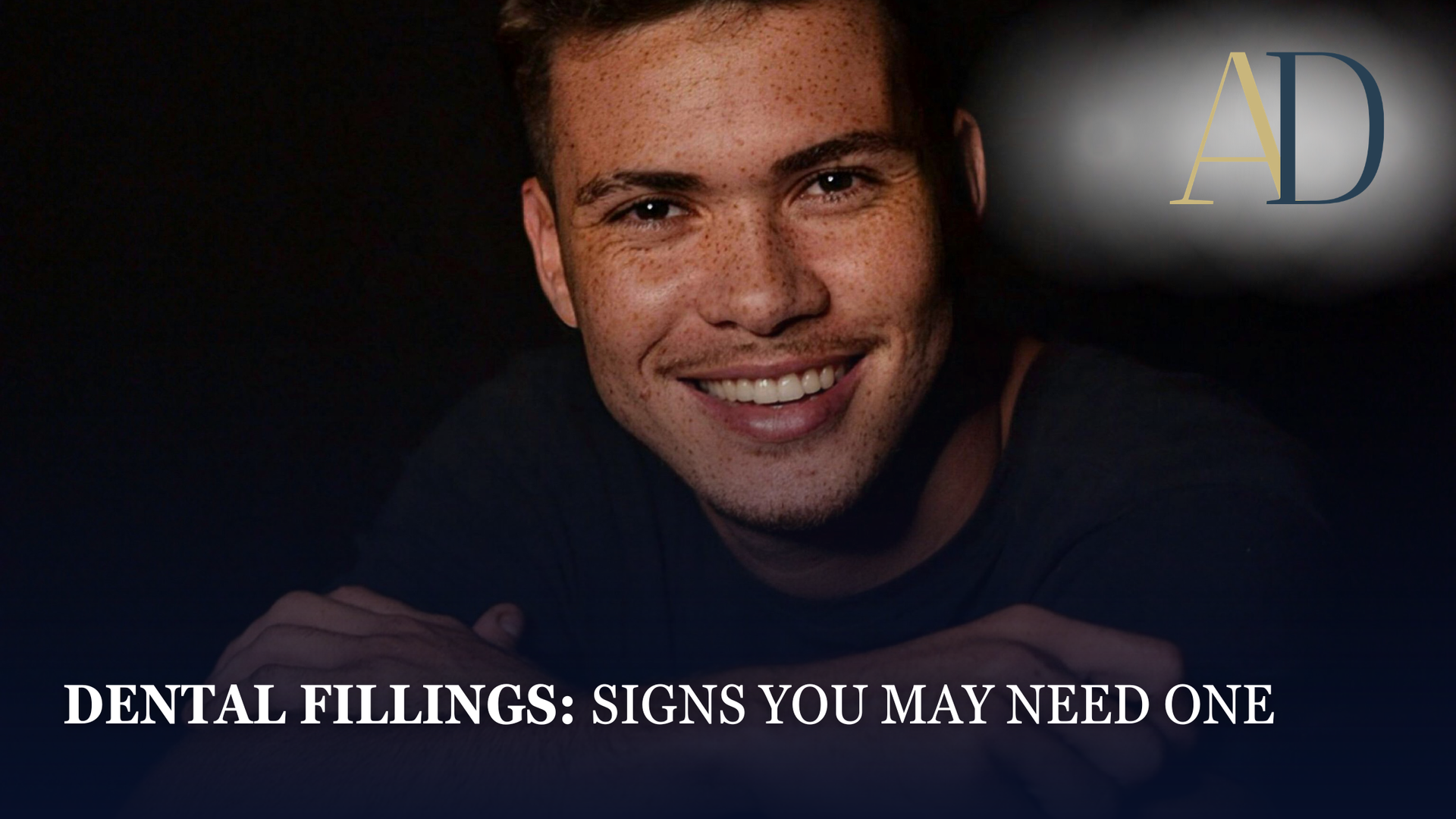 Smiling man on dark background with text “Dental Fillings: Signs You May Need One”