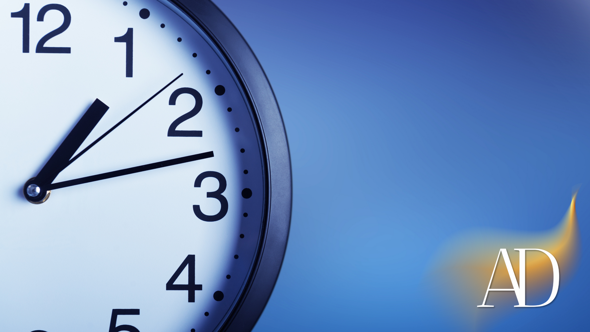 Close-up of a clock showing around 1:50 against a blue background with an AD logo
