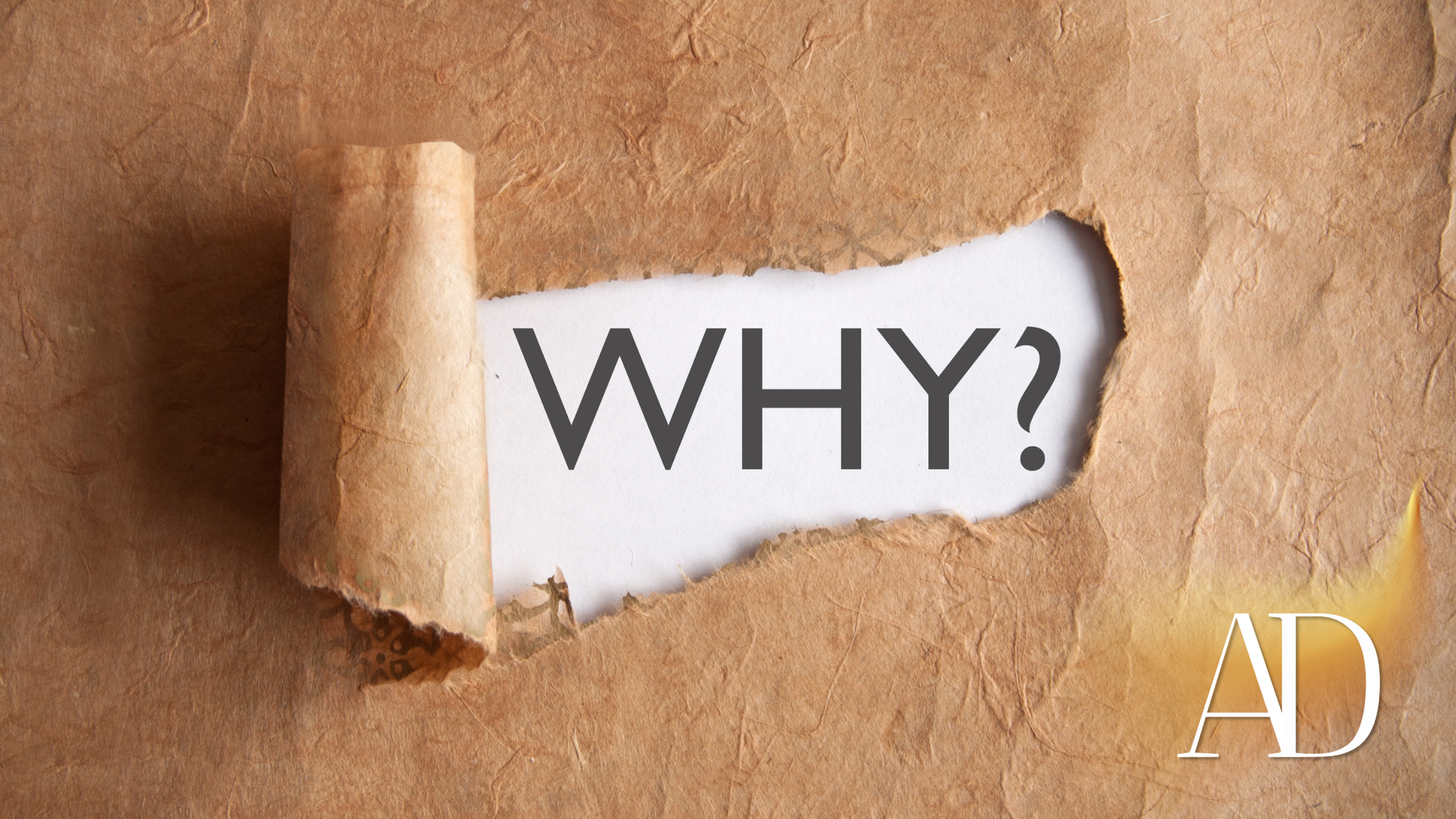 Torn paper revealing the word “WHY?” on a brown background, with an AD mark in the corner