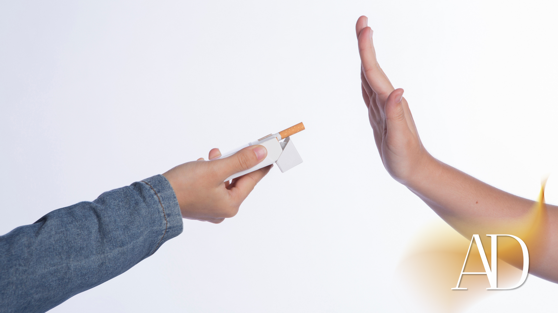 Hand holding a credit card toward a raised open palm in a white background.