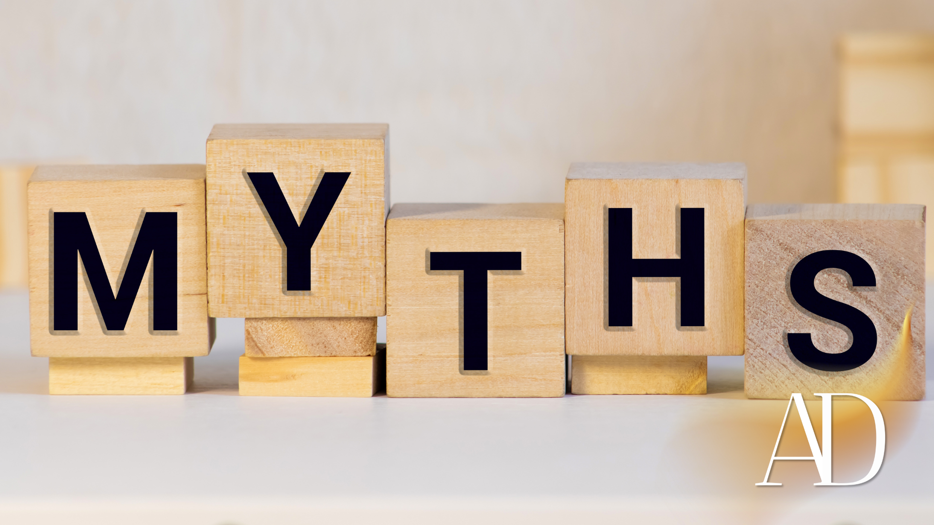 Wooden blocks spelling “MYTHS” on a light background