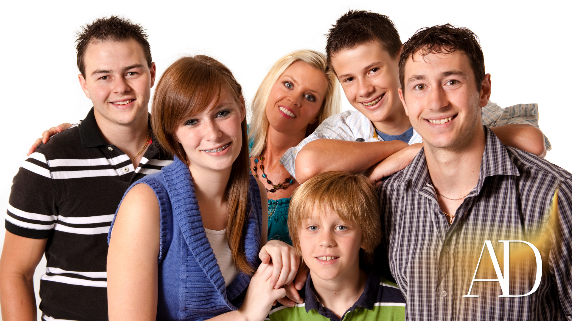 Smiling group posing together against a white background, with one child in front and one man on the right.