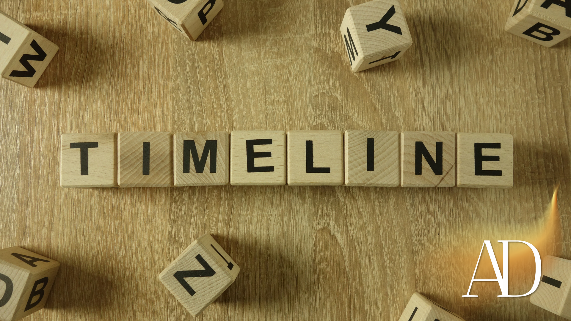 Scrabble tiles spelling “TIMELINE” on a wooden surface, with scattered letter tiles around them.