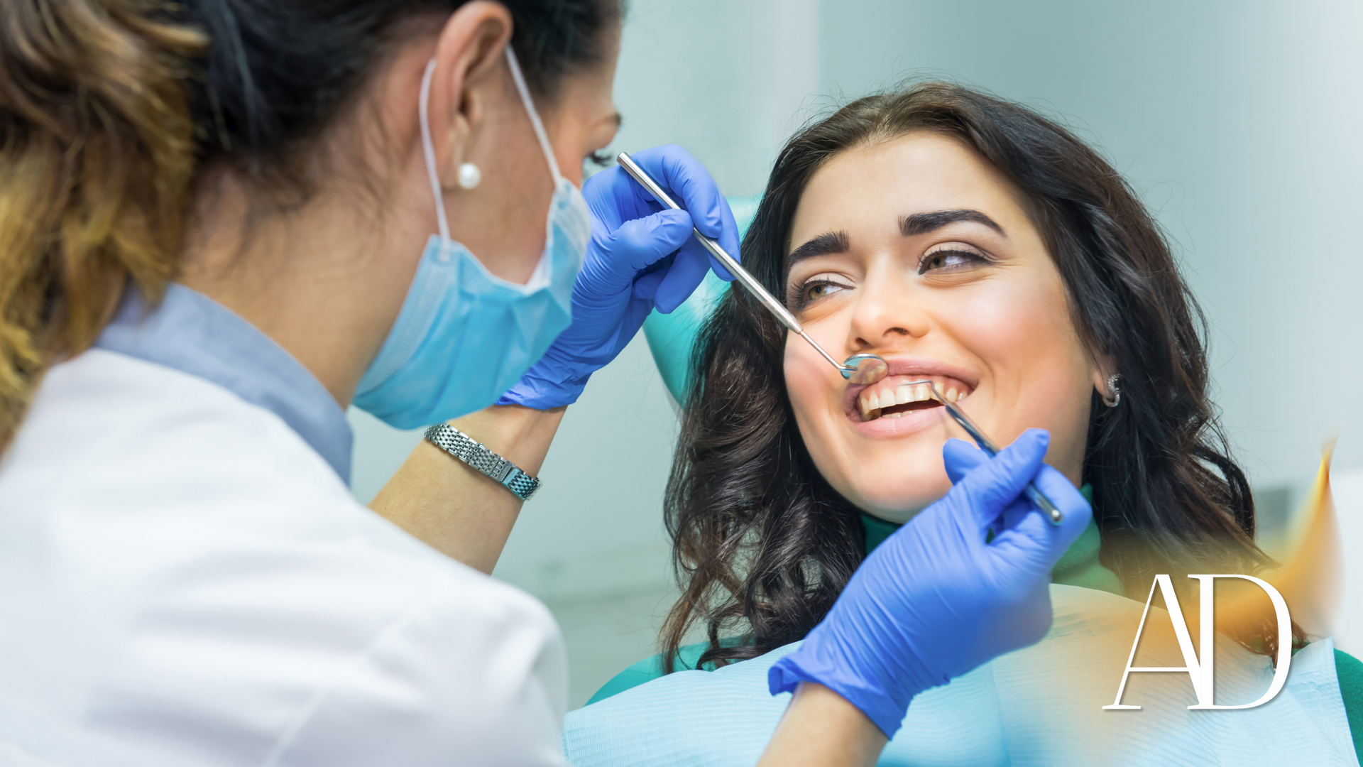 Dentist examining a smiling patient’s teeth with tools in a bright clinic