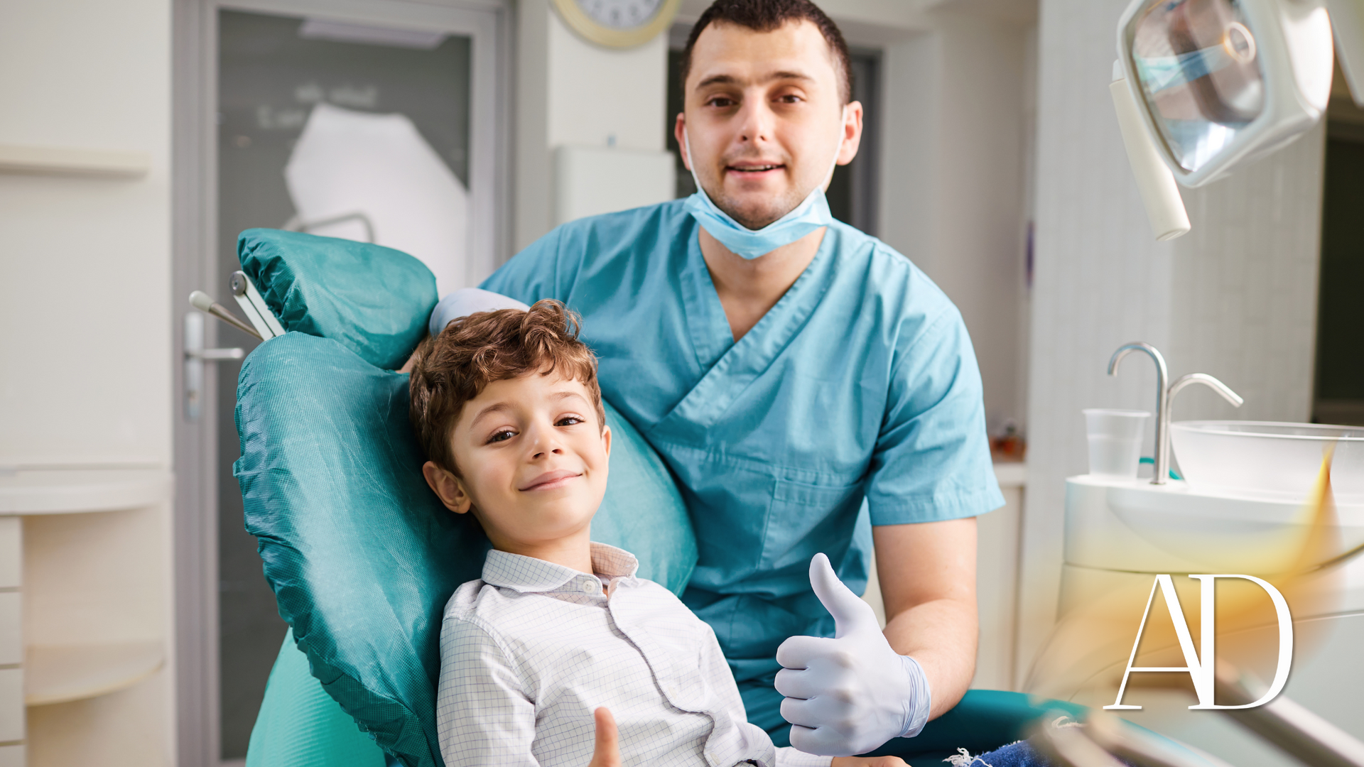 Dentist with a child in a dental chair, both smiling, in a bright clinic.