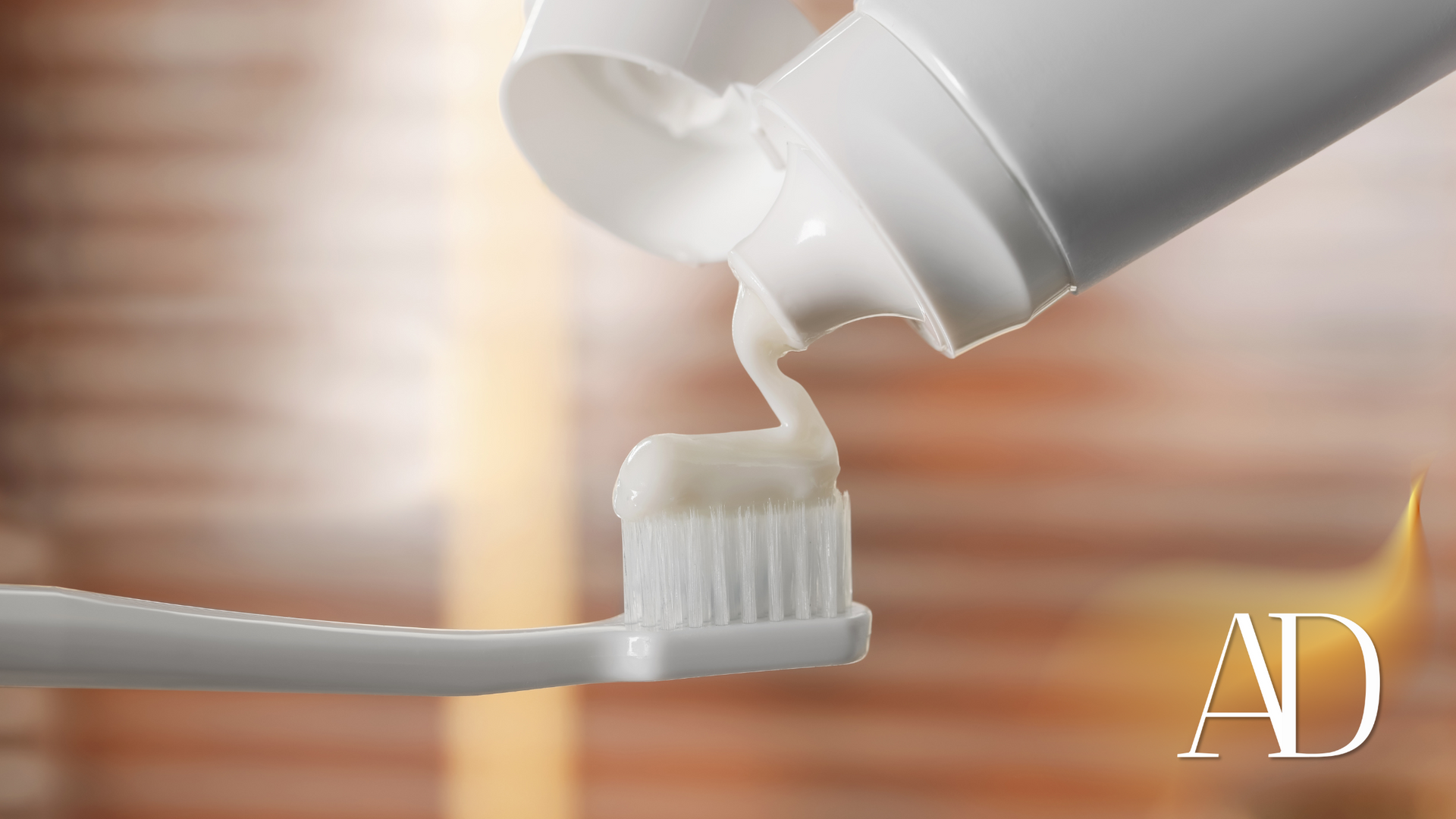 Toothpaste squeezed onto a toothbrush from a white tube, close-up with soft background