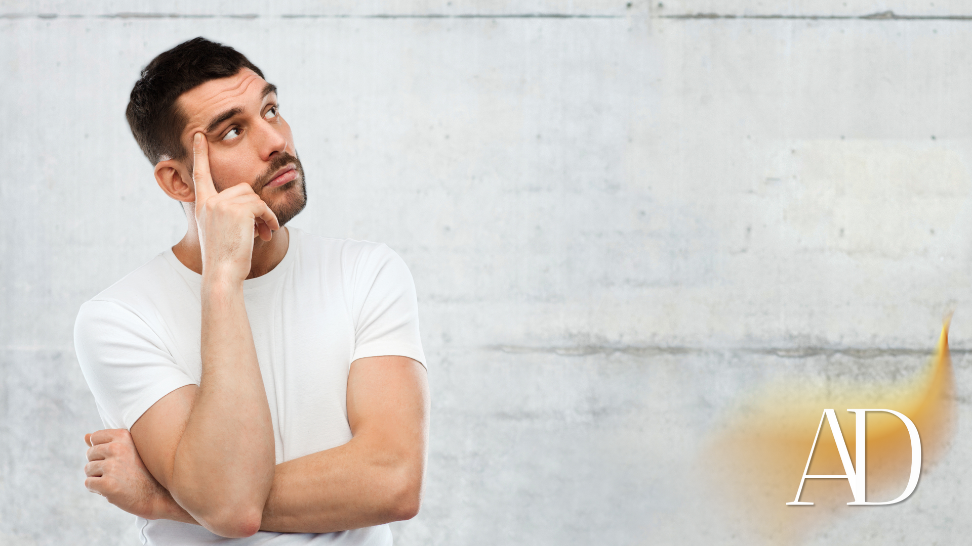Man in a white T-shirt leaning against a wall, looking up thoughtfully with the initials “AD” in the corner